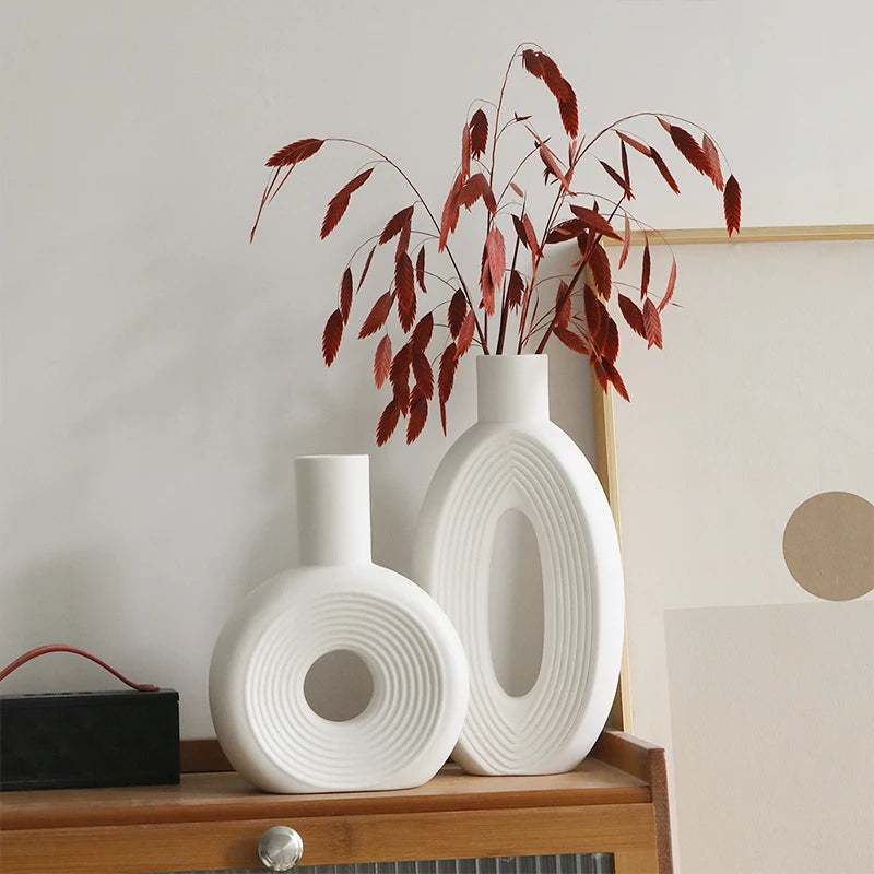 Vases Arche sculpturaux en céramique crème posés sur un meuble
