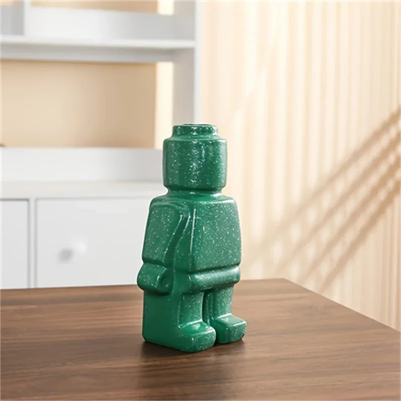 Vase Figura vert moucheté posé sur une table en bois