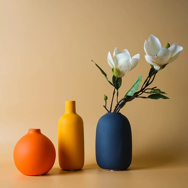 Trois vases Sienne en céramique mate, boule terracotta, bouteille ocre et galet bleu nuit