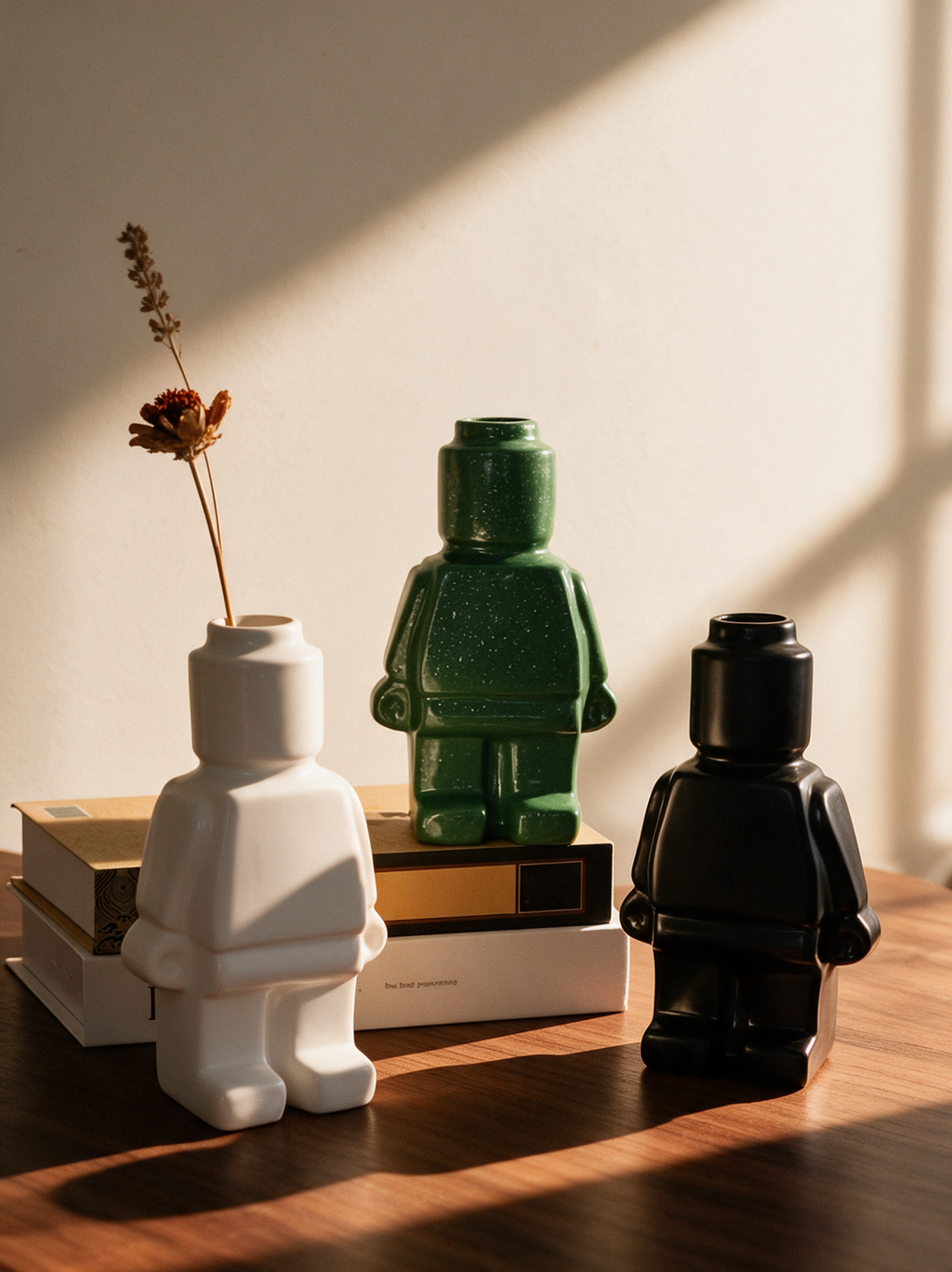 Trois vases Figura personnage blanc, vert moucheté et noir sur un bureau en noyer